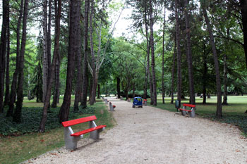 a red bench on a walkway on Margaret Island