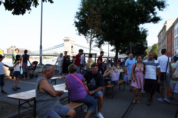 people sitting on benches placed on the street in Buda near Chain Bridge