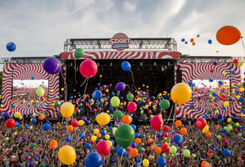 lots of people in front of the main stage, balloons in all color in the air