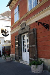 the red facade and wooden doors at the entrance of the pharmacy musuem