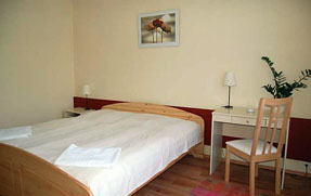 a room with a double bed, small table and chair in B and B hotel