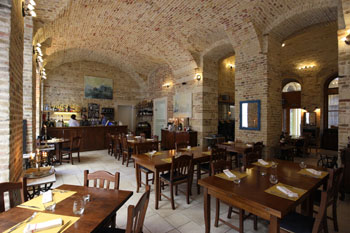 the rustic vaulted interior with a couple of dark wood tables and chairs