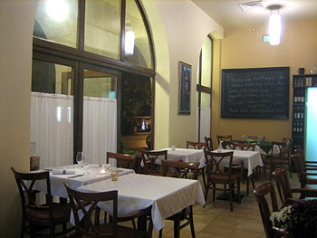 simple white clothed tables and chairs inside Csalogány 26 in the evening