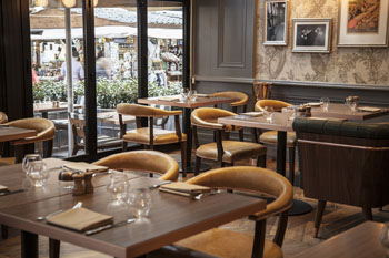 leather chairs around square tables, by a large window overlooking the street