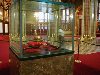 the crown on red pilow inside a glass cabinet