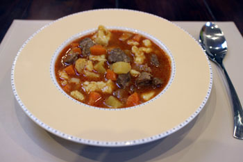 goulash served in a beige soup plate