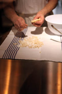  a woman pinching a piece of dough into small parts