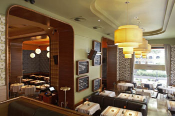 tables with retro cloth, large yellow lamps from the ceiling and a window overlooking the street