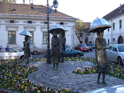 4 bronze statues of women with umbrella