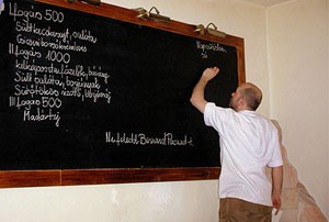 writing the menu on a black board Olimpia restaurant