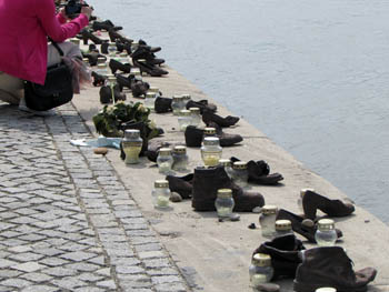 a woman in a pink jacket is taking photos of the "shoe" memorial