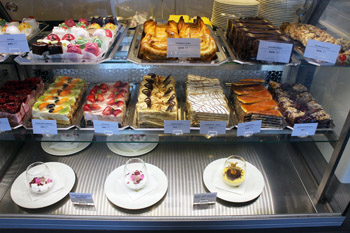 selection of cakes, pastries behind a glass counter 