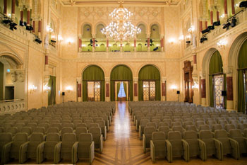 beige seats, large chandelier in the concert theatre