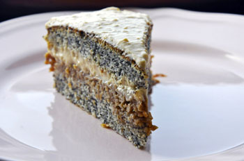 a slice of cake with layers of poppy seed sponge and stewed apple