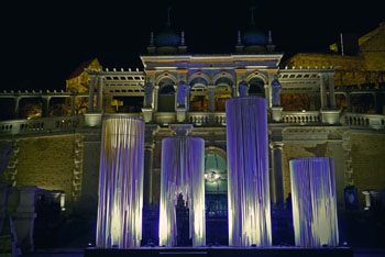 giant wood candles illuminated by purple light in front of the palace in Varkert