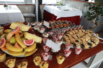 slices of cakes and various fruits (banana, melon ...) arranged nicely on the table