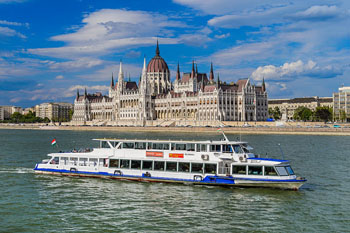 a white sightseeing boat in front of the Parliament
