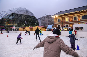 a couple of ice skaters on the rink in front of the Balna