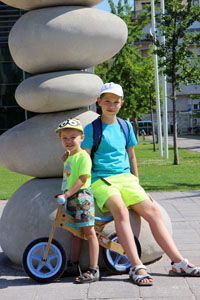 our two boys at a monument of giant pebbles in millenaris park