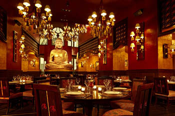 slightly dark interior of the restaurant with lots of lamps and a large Buddha statue in the background