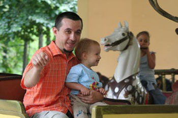 our 2 yr old boy with his father on a merry go round