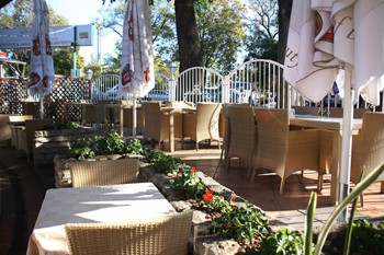 garden of the restaurant with rattan chairs and tables in the afetrnoon