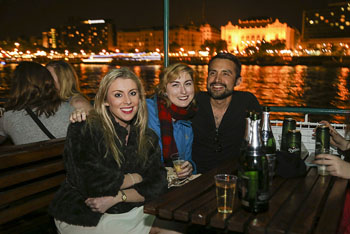 2 ladies and a man sitting on the open deck of a party boat