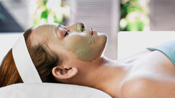 a green mud mask on a young lady's face