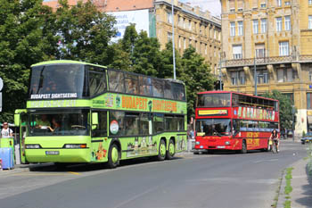 a lime green and a red double decker tour bus in the city center