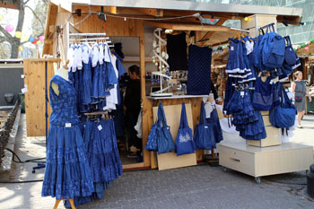 blue folk dresses a a wooden stall