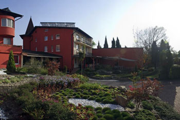 the red facade of the hotel and the garden 