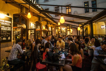 the busy terrace of Divino Gozsdu at dusk