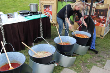 cooking stew in kettles over open fire in Millenaris park during the Gourmet Festival in May in Budapest