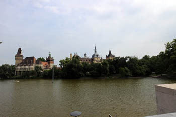 the lake with the towers of Vajdahunyad castle in the background on a cloudy morning