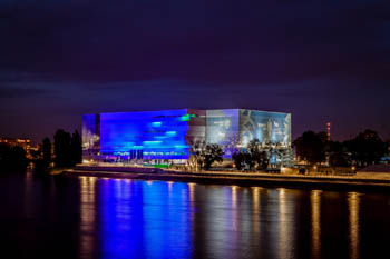 the facad eof the Arena light painted in blue at night