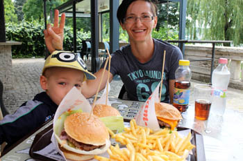 our 5 yr old boy and me eating burgers and fries at a terraced cafe