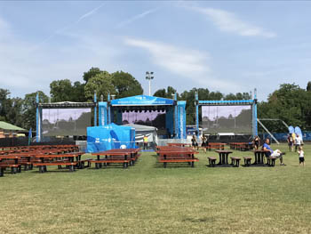 cherry brown benches and giant projectors on a grassy area