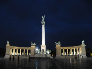 the Millennium monument with the tall column in the middle illuminated at night