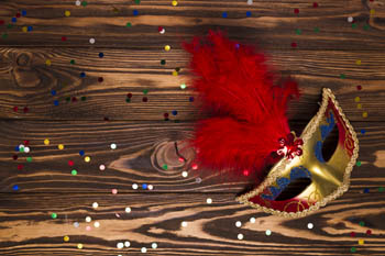 a red and gold carnival mask on a wooden surface - Carnival Season in Budapest
