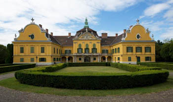 the yellow building of the castle museum and its garden on a clear day