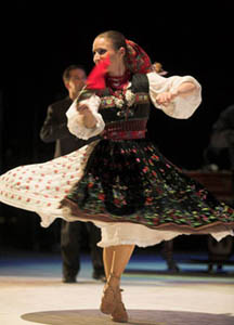 a woman in colorful folk costume performing a folk dance