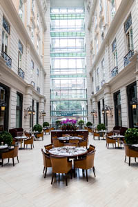 round wood tables with 4 chairs in the airy panorama windowed atrium