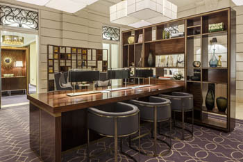 a marble top bar with 3 dark brown leather bar armchairs