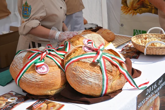 A couple of loaves of bread cross tied with ribbon in the Hungarian national tricolor