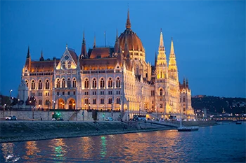 The Parliament in Budapest lighted up at dusk during the blue hour. Photo taken on a cruise ship on the Danube