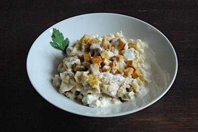 vegan version of cottage pasta in a white ceramic bowl, placed on a dark brown table