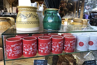 Festive Xmas Mugs in red and white design placed in a glass display case