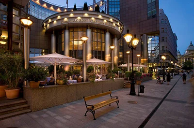 street view of the Kempinski Corvinus hotel at dusk with the lights on