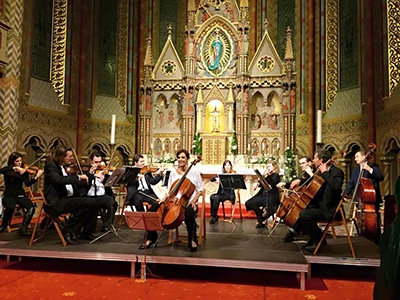 An orchestra playing in front of the ornate main alatra of Matthias Church