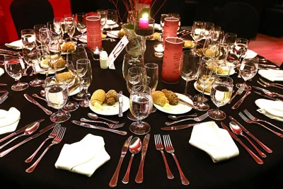 a round table elegantly set with black cloth, silverware and candels on the Europa ship